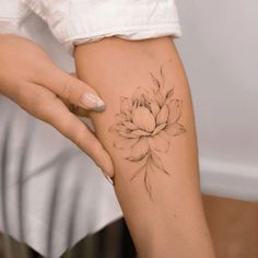 a woman's arm with a flower tattoo on the left side of her body