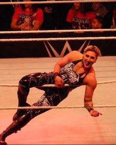 a man is wrestling in an arena while people watch