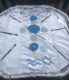 a metal pan covered in tin foil with various tools on it and some sticks sticking out of the top