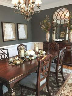 a dinning room table with chairs and pictures on the wall