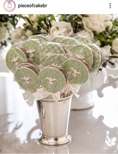 some cookies are in a silver vase on a table