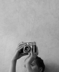 a woman holding up a camera in front of her face