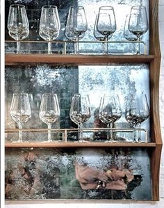 wine glasses are lined up on a shelf