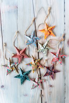 colorful origami stars hanging from string on wooden background