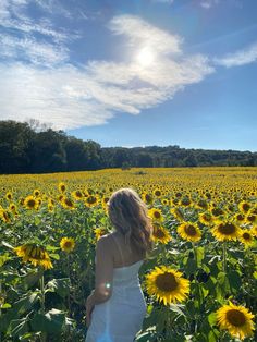 a woman standing in a field of sunflowers