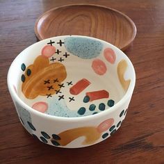 a wooden bowl with an animal design on the bottom and sides, sitting on a table