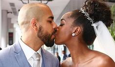 a bride and groom kissing each other in front of the camera on their wedding day