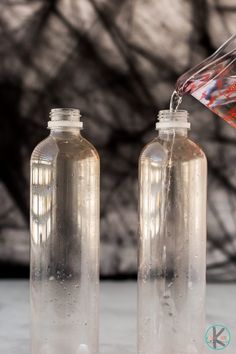 two bottles filled with liquid sitting on top of a table