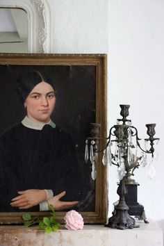 a portrait of a woman with her arms crossed next to a candle