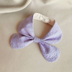 a blue and white bow tie laying on top of a bed