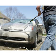 a man is washing his car with a high pressure washer