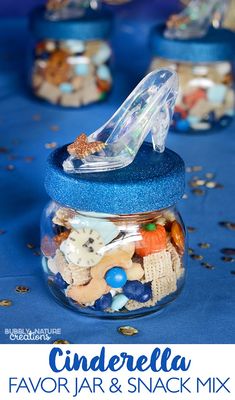 a jar filled with sand and sea shells next to confetti on a blue table cloth