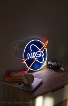 the nasa neon sign is on top of a desk