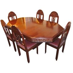 a wooden dining table with six chairs and a center piece on the back drop leaf