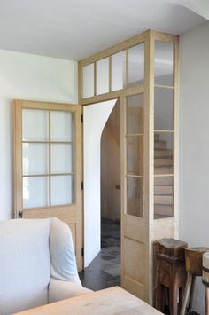 a living room filled with furniture and wooden doors