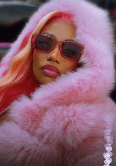 a woman with pink hair wearing sunglasses and a fur coat