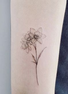 a small flower tattoo on the arm