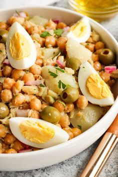 a white bowl filled with food next to chopsticks and an egg on top