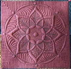 a close up of a pink quilted piece of cloth with an intricate design on it