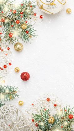 christmas ornaments and pine branches against a white background