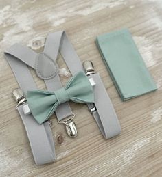 Your special guy will look so handsome when he shows up in his Dusty Sage / Agave bow tie, pocket square and Light Gray suspenders!  Great set for groomsman, best man or ring bearers - This bow tie & suspenders set is a great choice for family photos, wedding, ring bearer outfit, birthday celebration or any other special occasion.  When making a purchase, you can choose from the following options : -Suspenders Only -Bow Tie Only. -Suspenders + Bow Tie Set. - Pocket Square only. -3 Pieces Set : bow tie + suspenders + pocket square . Attention ! We Will not accept any  returns based upon color discrepancies - Please contact for FREE color samples .  Pocket Square : SIZE : 9.5" X 9.5" Made out of 100% cotton fabric . Each bow tie comes pre-tied and made with adjustable strap . You can also wr Ring Bearer Outfit Rustic, Gray Braces, Sage Bow Tie, Boho Wedding Groomsmen, Grey Suspenders, Outfit Birthday, Rustic Boho Wedding, Bearer Outfit, Wedding Gifts For Groomsmen