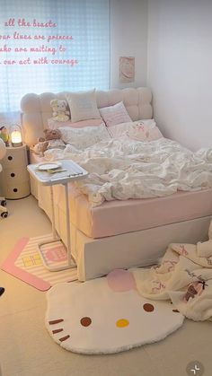 a bedroom with hello kitty bedding and pink accessories on the floor in front of a window