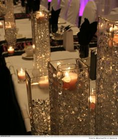 some candles are sitting in vases on a table