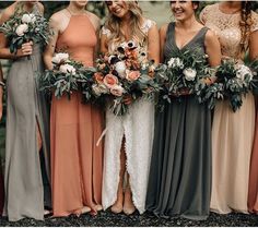 a group of women standing next to each other wearing dresses and holding bouquets in their hands