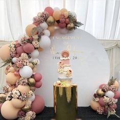 a wedding cake surrounded by balloons and flowers in front of a sign that says engagement