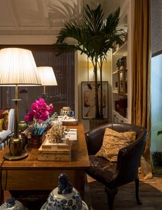 a living room filled with lots of furniture and flowers on top of a wooden table