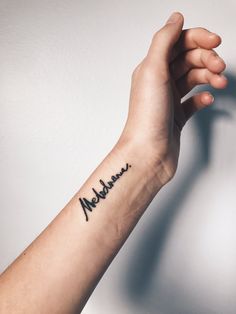 a person's arm with a tattoo that reads mellows on it and the word mellows written in cursive font