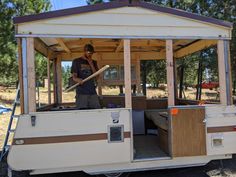 a man standing in the back of a trailer with a baseball bat on top of it