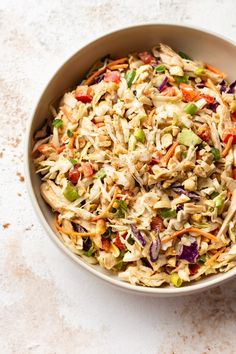 a bowl filled with coleslaw and carrots on top of a white table