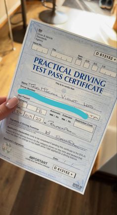 a person holding up a driving test pass