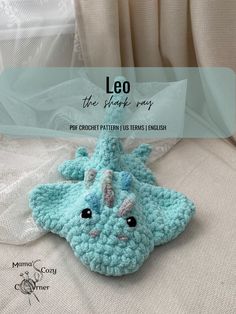 a blue crocheted stuffed animal laying on top of a white bed with text overlay that reads leo the simple story