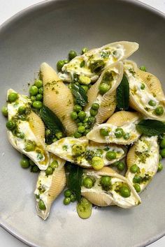 a plate filled with pasta and peas on top of a table