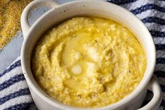 a white bowl filled with yellow food on top of a blue and white towel