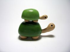 a small green toy sitting on top of a white table