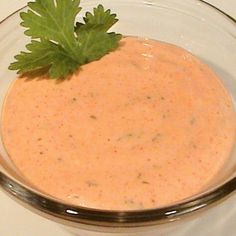 a glass bowl filled with sauce and garnished with parsley