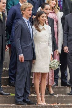 the couple are posing for pictures on the steps in front of their wedding ceremony guests