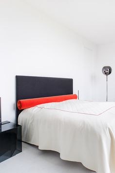 a bed with white sheets and a black headboard