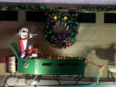 an outdoor christmas display with decorations and lights on the side of a garage door in front of a clock