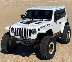 a white jeep parked on top of a sandy beach