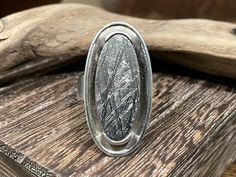 "Swedish Meteorite Ring/ 925 Sterling Silver/ Size 8 Adjustable/ Muonionalusta Meteroite/ This is an amazing piece of history! The Muonionalusta is known for its famous Widmanstätten Pattern, beautiful etching created in outer space. An amazing choice for any Meteroite collector, or jewelry lover. Great condition and craftsmanship!  Weight 15.28 g. / .539 oz.  Length 1 3/8\" Width 3/4\" The Muonionalusta meteorite is a meteorite classified as fine octahedrite. It impacted northern Scandinavia, west of the border between Sweden and Finland, about one million years BCE. The Muonionalusta is the oldest known meteorite to man, this meteorite has experienced four ice ages.  All items are sold as they are listed. No resizing." Silver Oval Etched Ring, Oval Silver Etched Ring, Etched Oval Silver Ring, Artisan Silver Oval Engraved Ring, Artisan Silver Engraved Oval Ring, Artisan Engraved Oval Silver Ring, Artisan Silver Ring With Large Stone, Unique Silver Ring For Memorial, Meteorite Jewelry