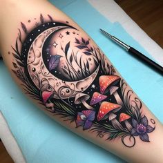 a woman's leg with a tattoo on it and the moon in the middle