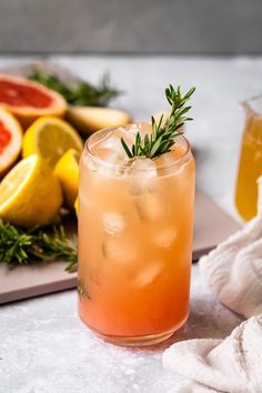 a close up of a drink on a table with grapefruit and lemons