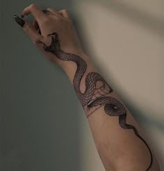 a woman's arm with a snake tattoo on it