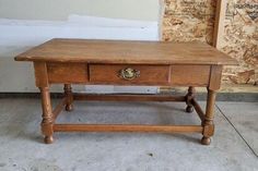 an old wooden table with two drawers on one side and a drawer on the other