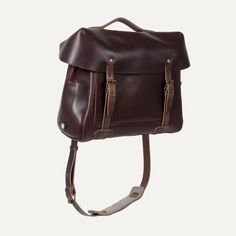 a brown leather bag with straps hanging from it's shoulder strap and the bottom section is