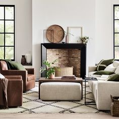 a living room with couches, chairs and a fire place in the middle of it